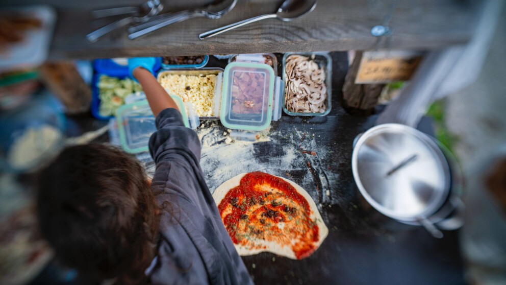 Pizza belegen auf der Pizzatheke neben dem Pizzaofen.