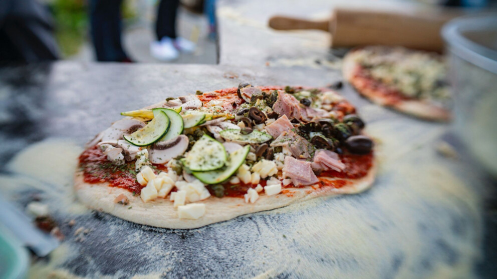 Grosszügig belegte Pizza auf einem Bett aus Mehl und Hartweizengriess