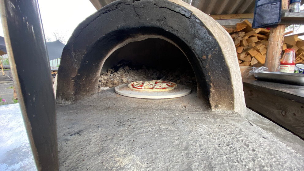 Pizza auf dem Pizzastein im Pizzaofen.